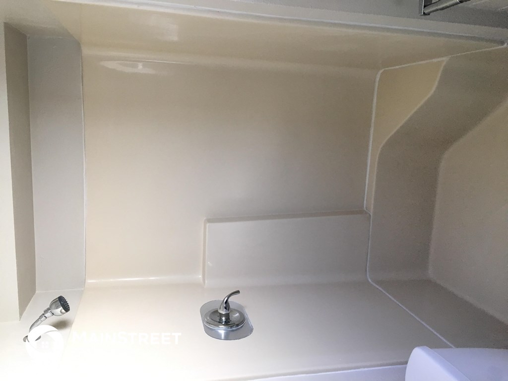 a white bathroom with a sink and a faucet in it