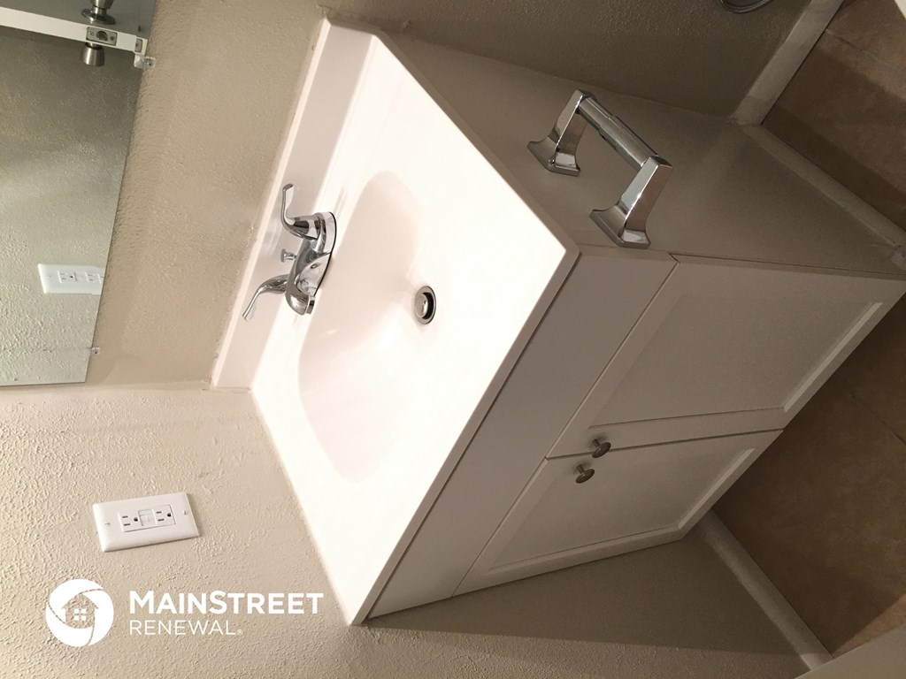 a bathroom with a sink and a mirror in it