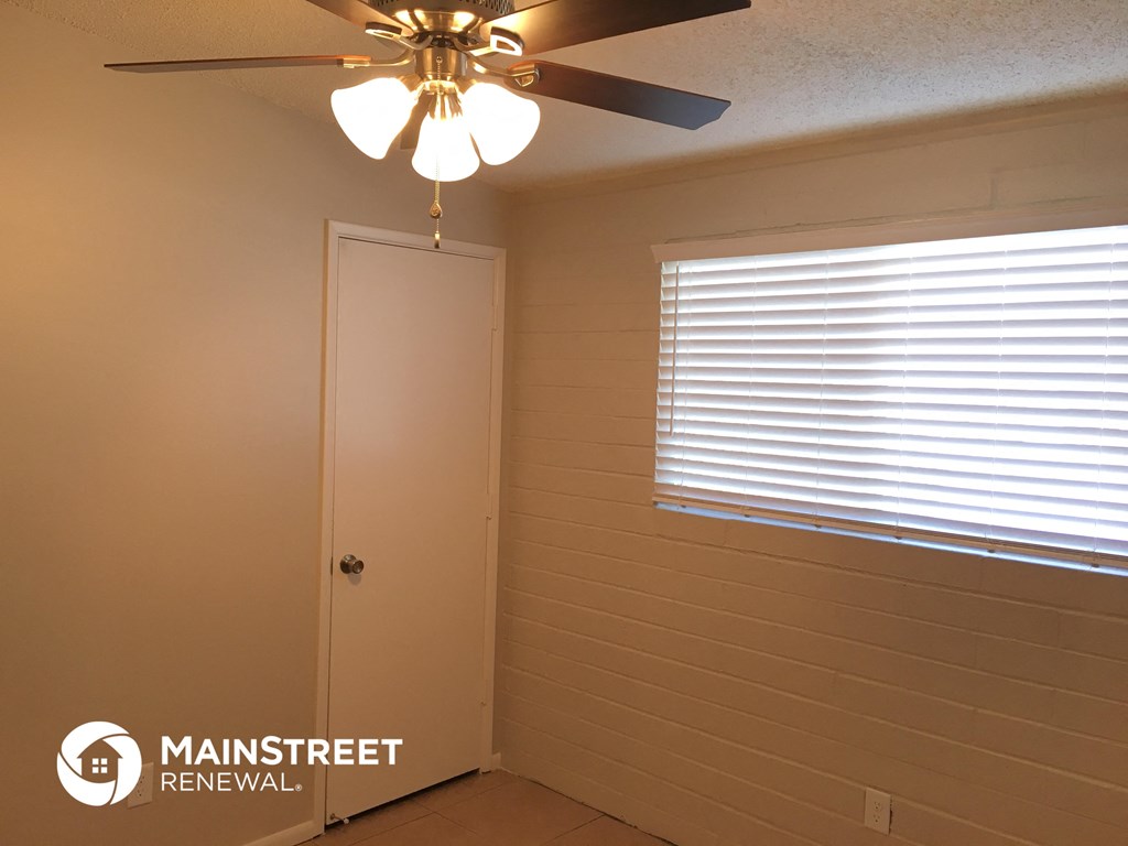 a room with a ceiling fan and a window and a door