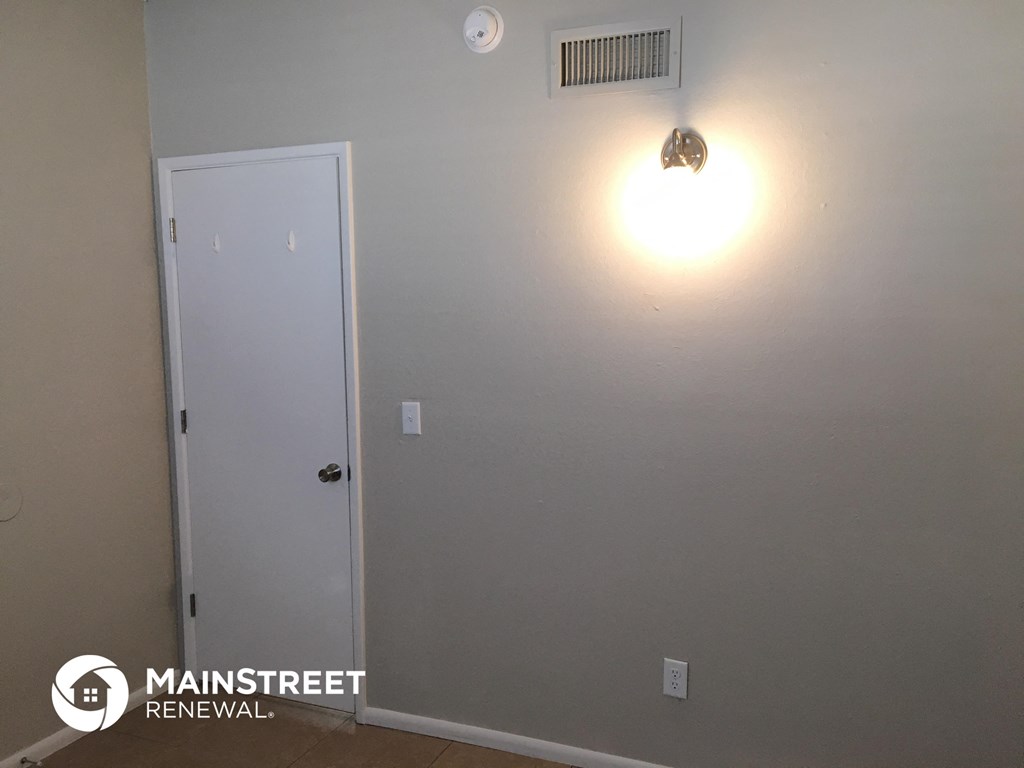 a room with a white door and a light on the wall