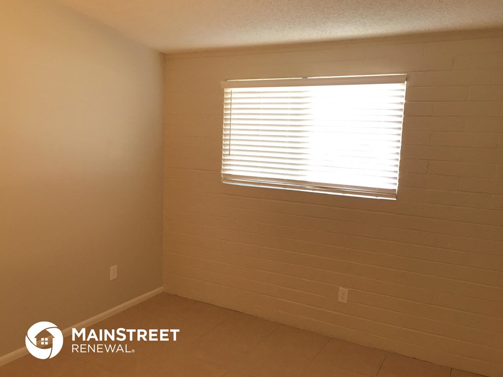 a small room with a window and a tiled floor