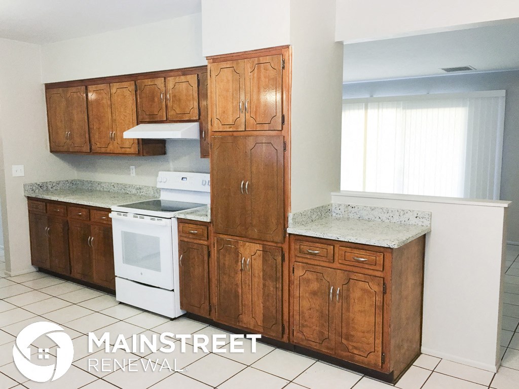 a small kitchen with wooden cabinets and white appliances
