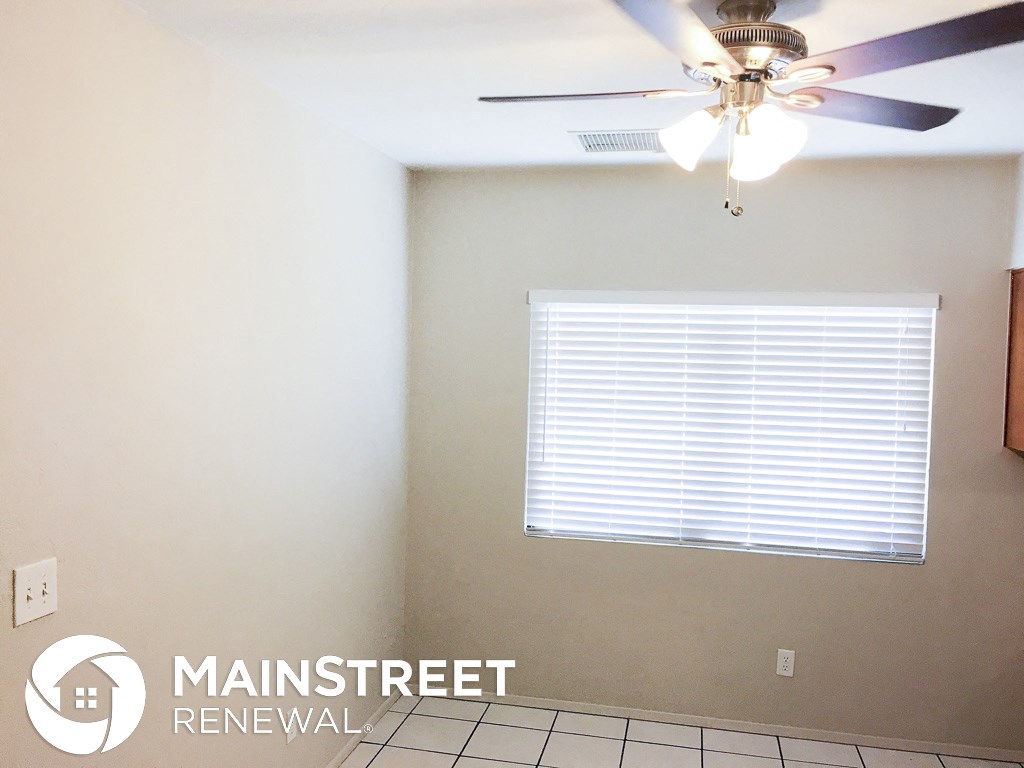 a living room with a ceiling fan and a window