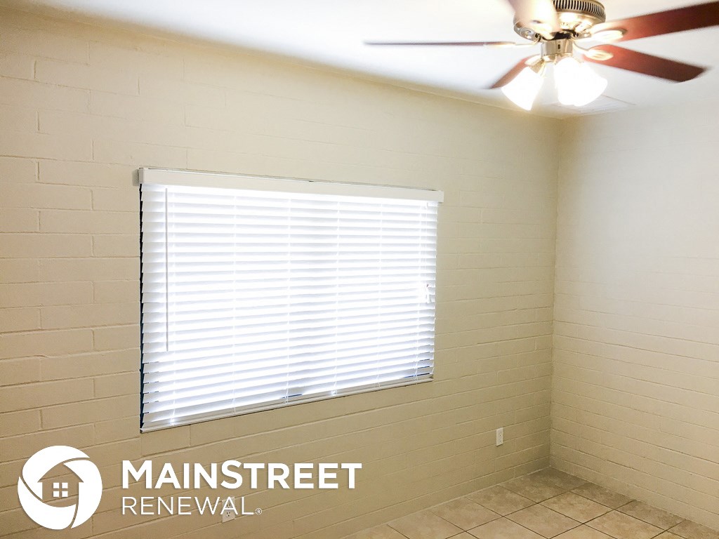 a small bathroom with a window and a ceiling fan