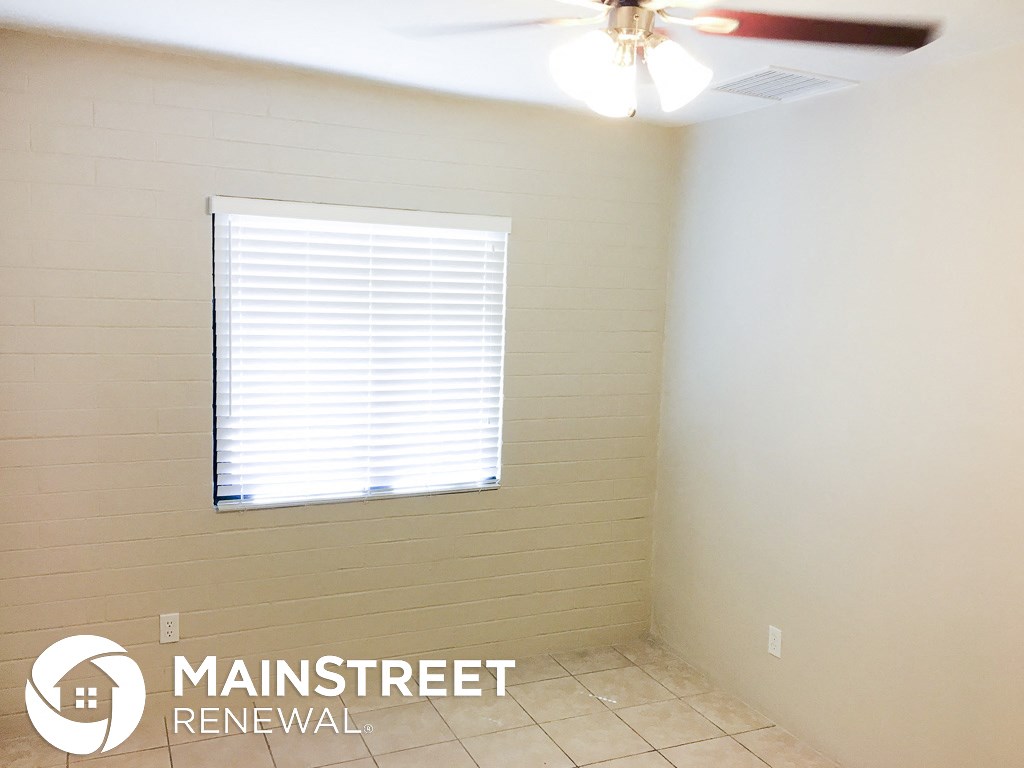 a small room with a window and a ceiling fan