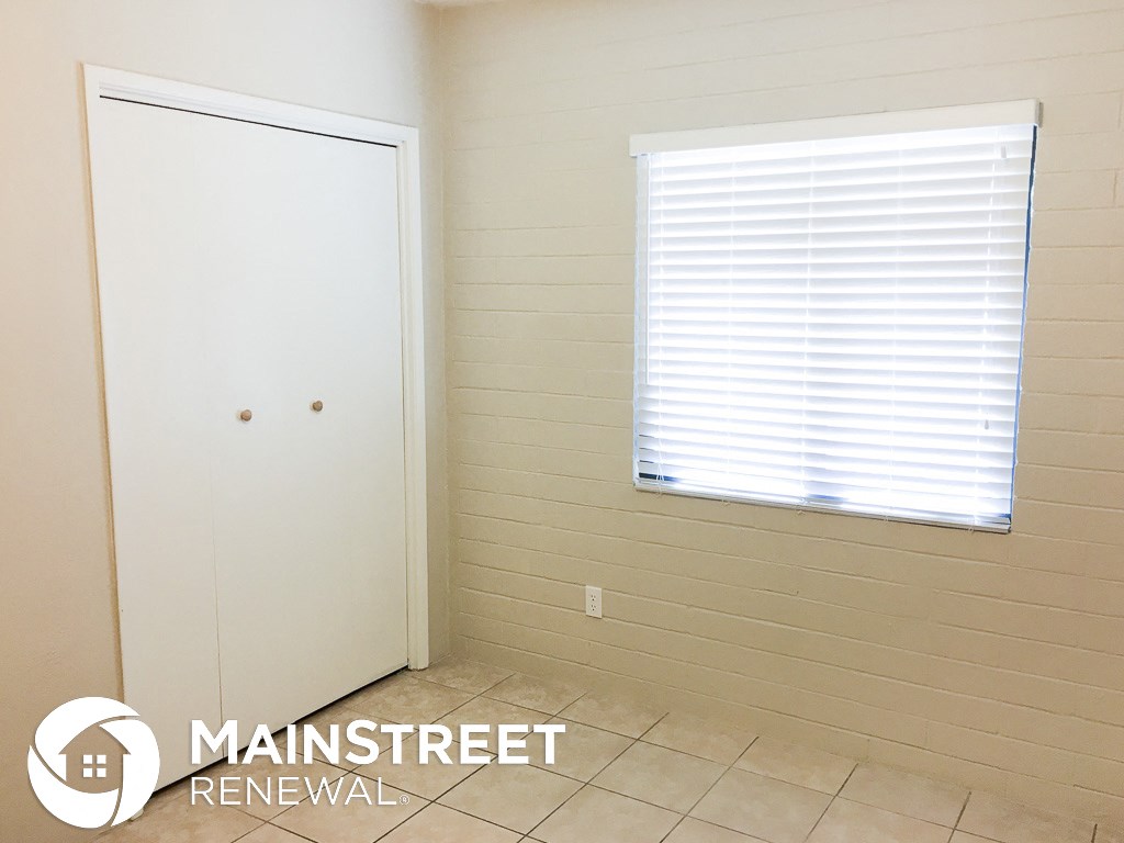 a bathroom with a door and a window and a tiled floor