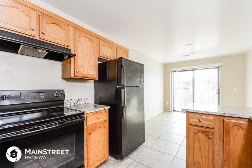 a kitchen with wooden cabinets and a black refrigerator