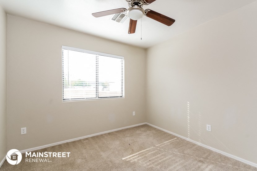a bedroom with a ceiling fan and a window