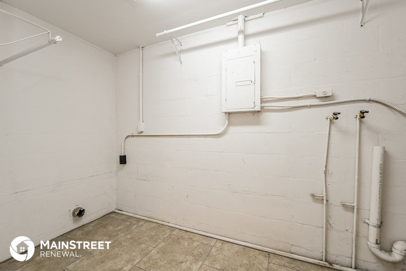 a small bathroom with white walls and pipes and a toilet