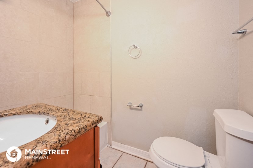 a bathroom with a toilet and a shower and a sink