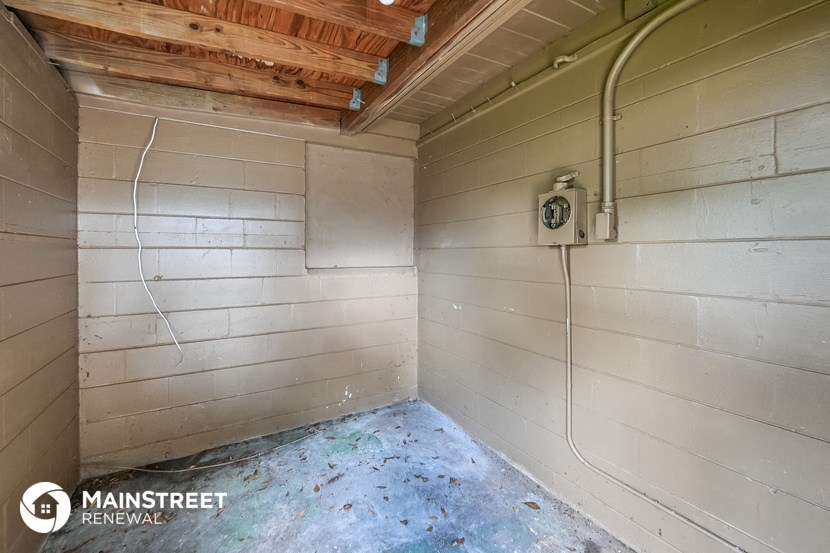 the inside of a shower in a shed with a blue floor and a white wall