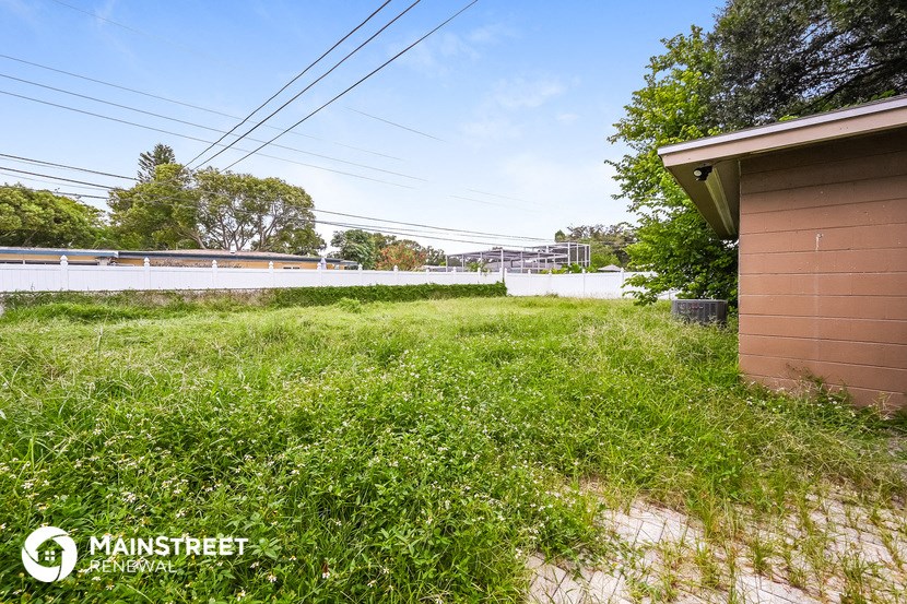 a backyard with a shed and a fence and a field of grass