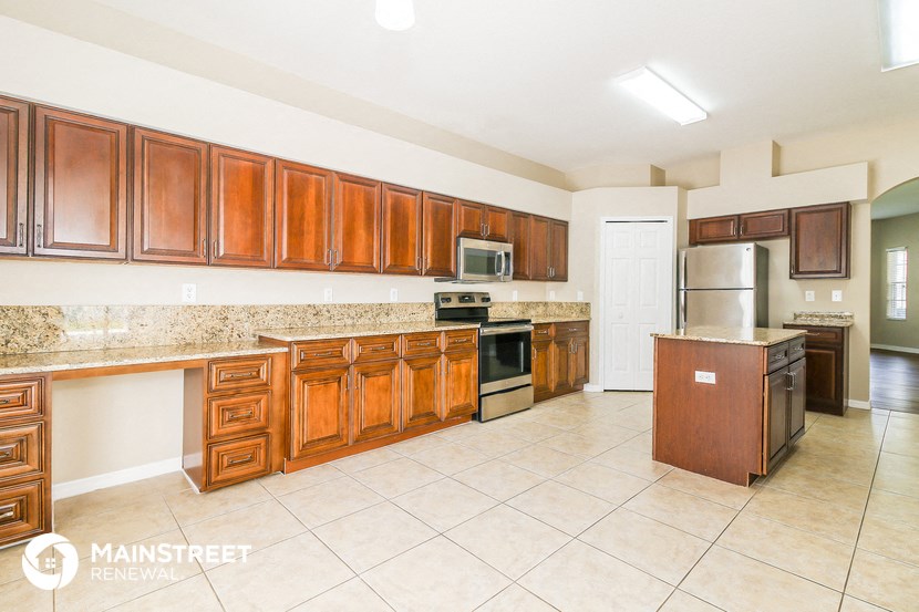 a large kitchen with wooden cabinets and stainless steel appliances