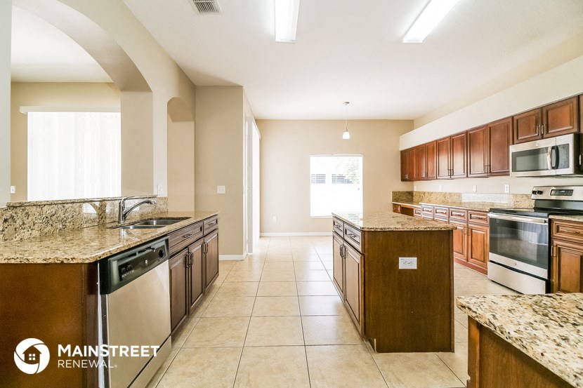 a large kitchen with granite counter tops and wooden cabinets