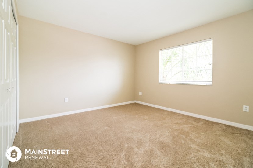 a bedroom with carpeted floors and a window