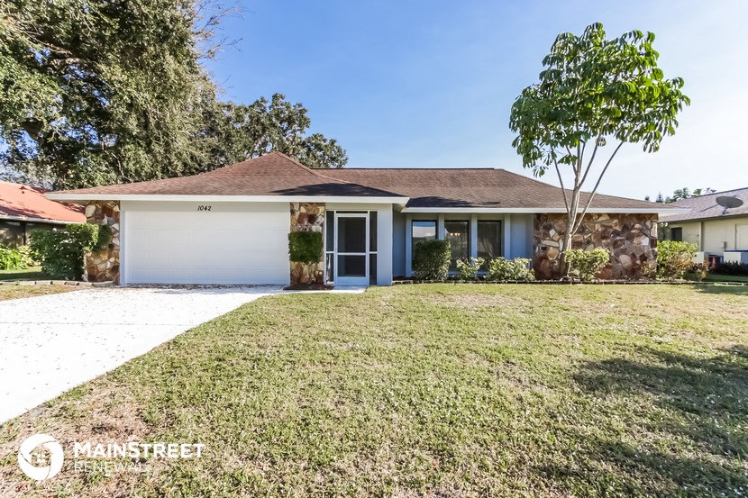 a home with a lawn and a white garage door
