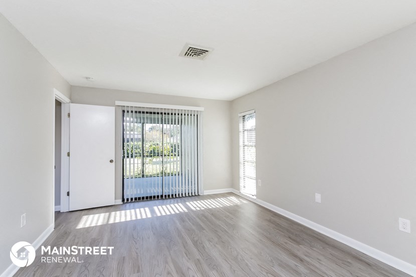 an empty living room with a door and window