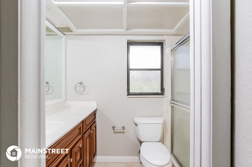 a bathroom with a toilet and a shower and a sink