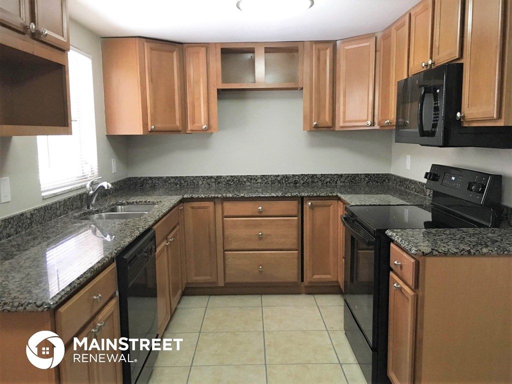 a kitchen with wooden cabinets and granite counter tops