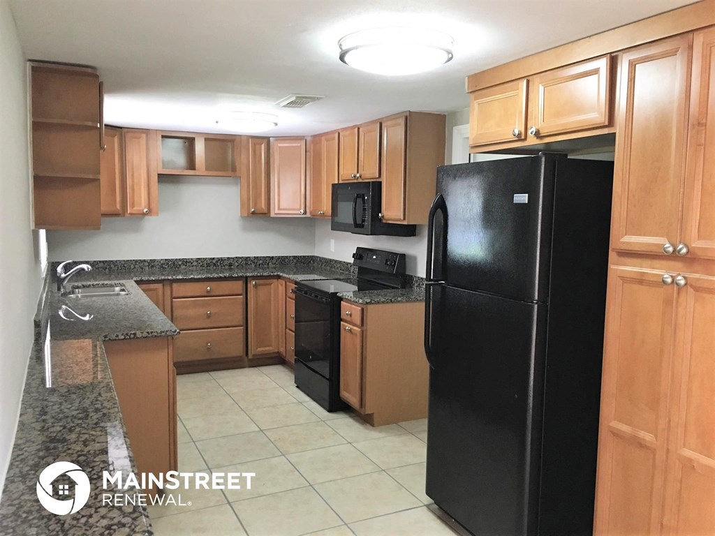 a kitchen with black appliances and wooden cabinets