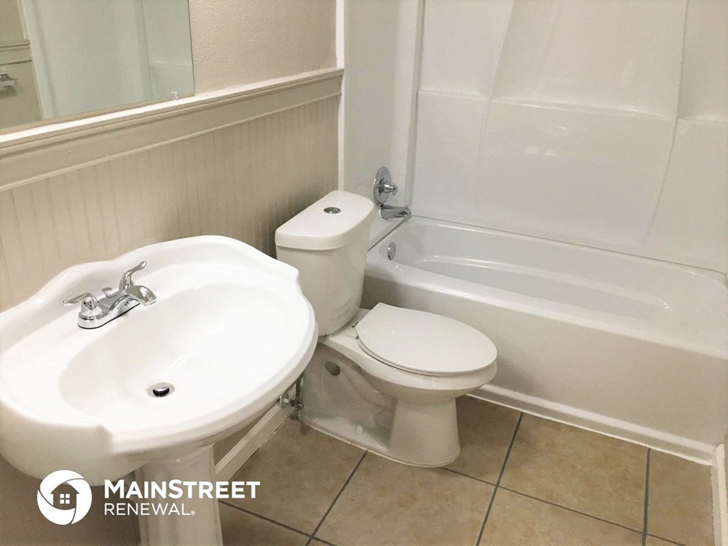 a bathroom with a toilet and a sink and a tub
