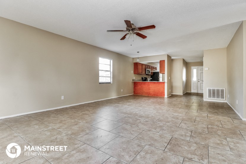 the living room and kitchen are spacious with tile floors and a ceiling fan