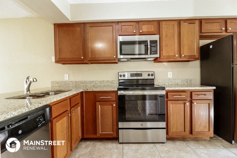 a kitchen with wooden cabinets and stainless steel appliances