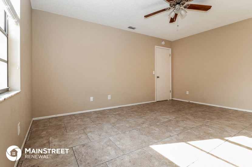 a empty room with a ceiling fan and tile floor