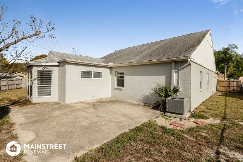 a small white house with a driveway and a garage door