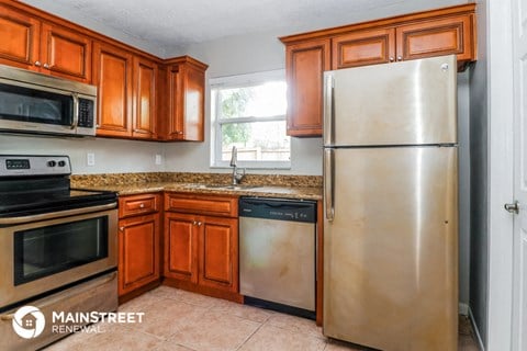 the kitchen has stainless steel appliances and wooden cabinets