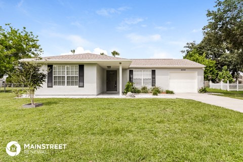 a white house with a lawn and a garage