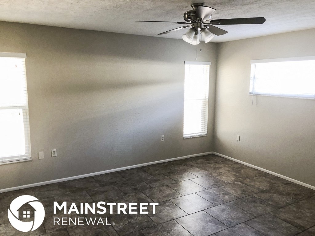 an empty room with a ceiling fan and tile floor
