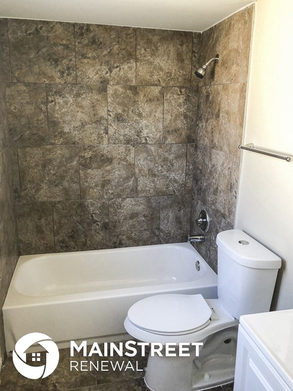 a small bathroom with a toilet and a bath tub