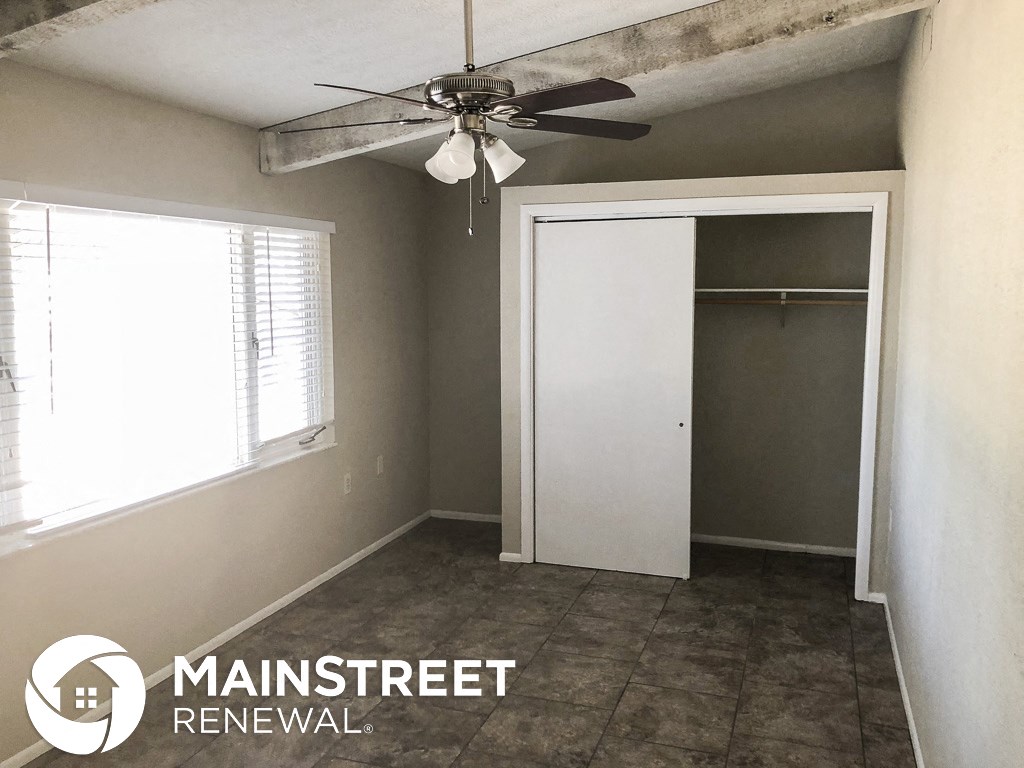 an empty room with a ceiling fan and a closet