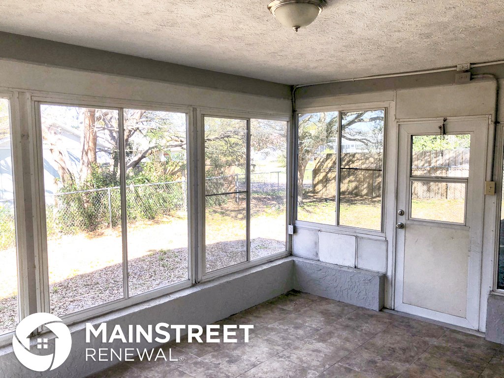 an empty room in a house with large windows