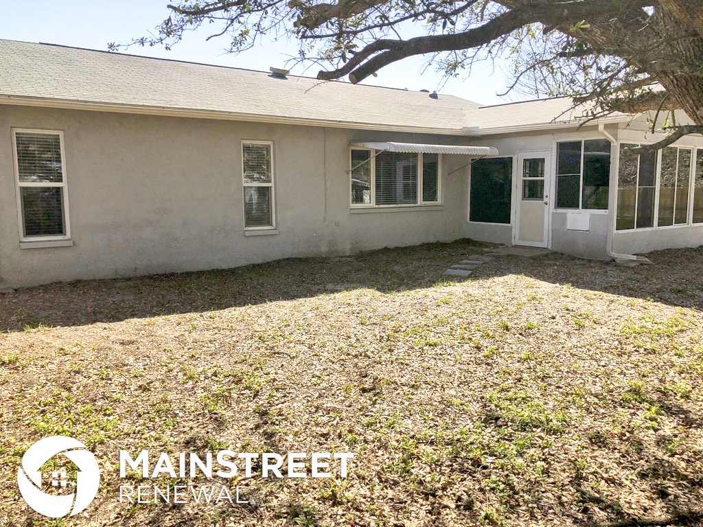 a small white house with a yard and a tree