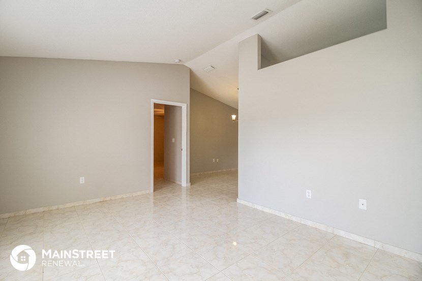 the living room and dining room of an empty apartment