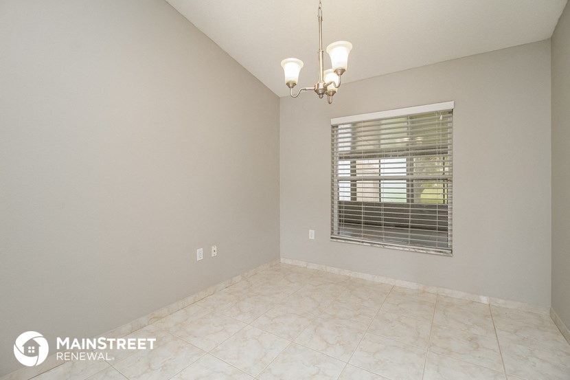 the spacious living room with a large window and tile flooring