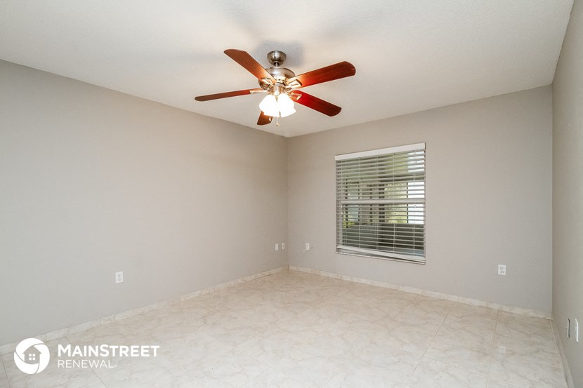 the spacious living room with ceiling fan and tile flooring