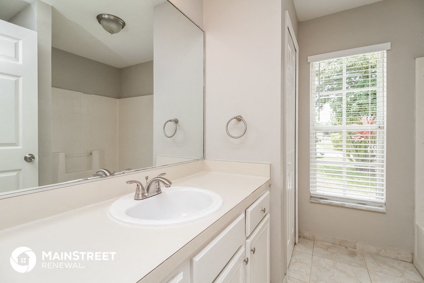 a bathroom with a sink and a mirror and a window