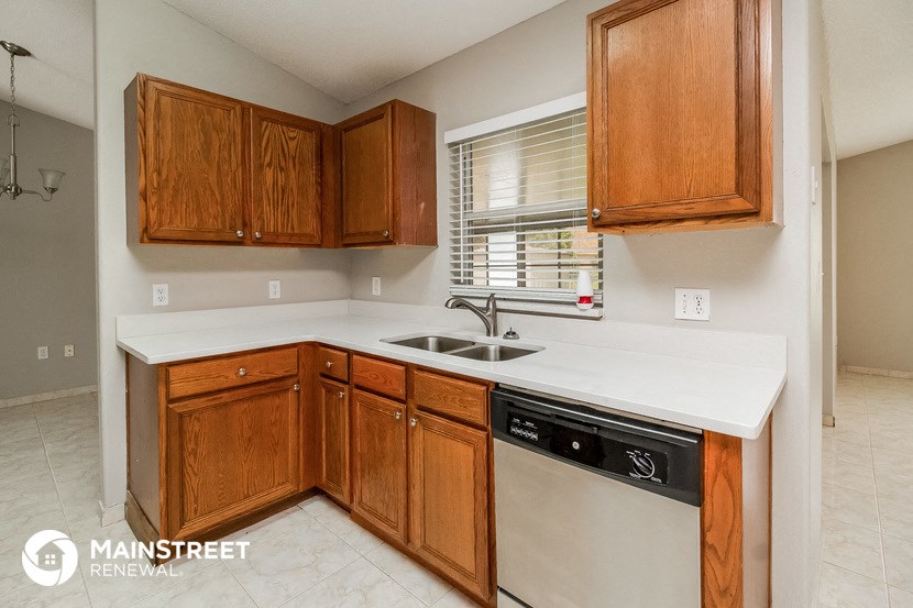 a kitchen with wooden cabinets and a sink and a window