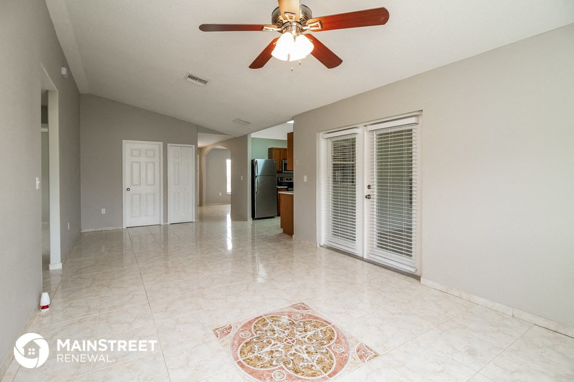 a large living room with a ceiling fan and a tile floor