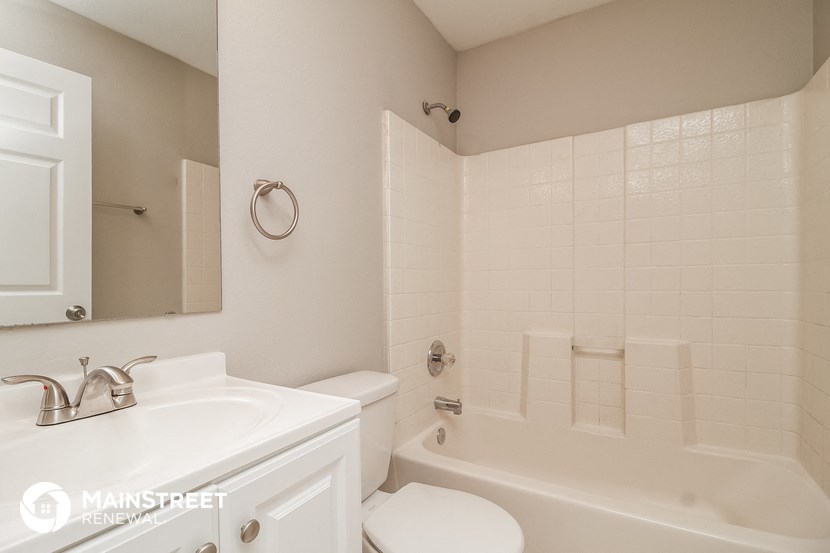a white bathroom with a tub and a sink and a toilet