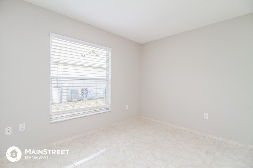 an empty room with a window and a tiled floor
