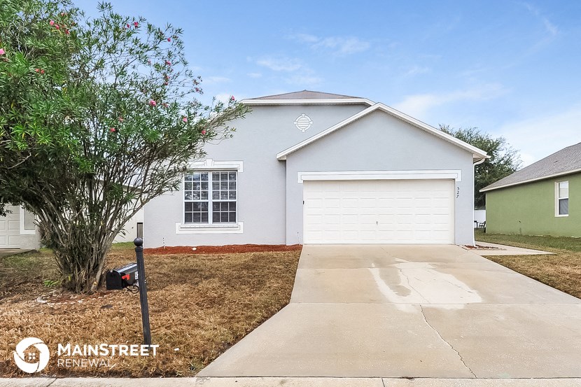 a blue house with a driveway and a garage door