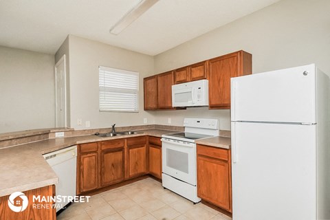 a kitchen with white appliances and wooden cabinets