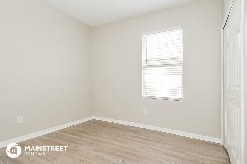 the interior of a white room with wood floors and a window
