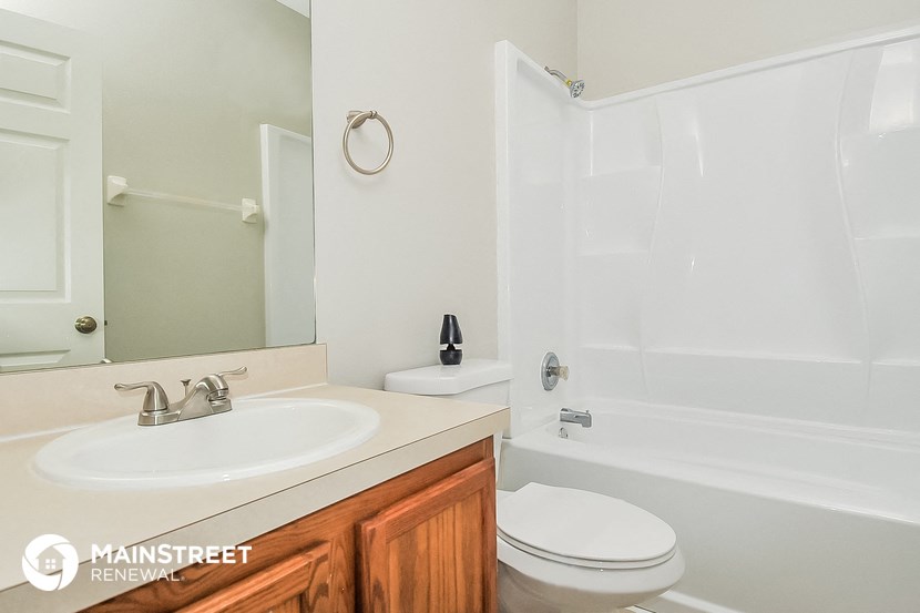 a bathroom with a sink toilet and shower and a mirror