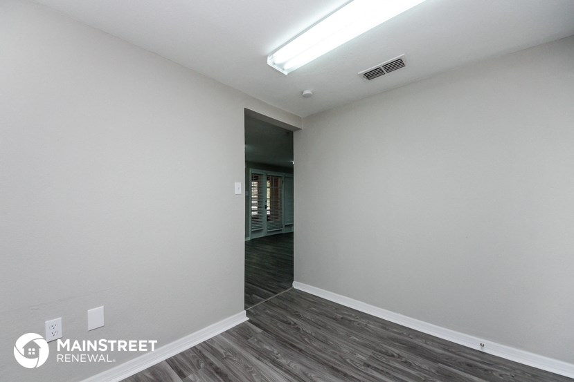 the living room of a new home with white walls and wood flooring