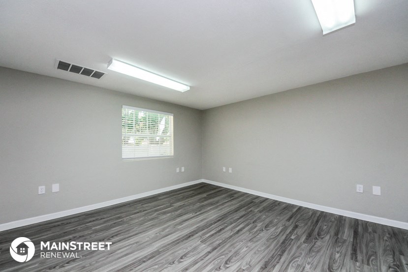 the interior of an empty room with vinyl flooring and a window